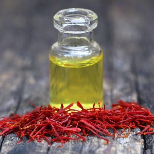 Closeup of Saffron with extract in a bottle on natural surface